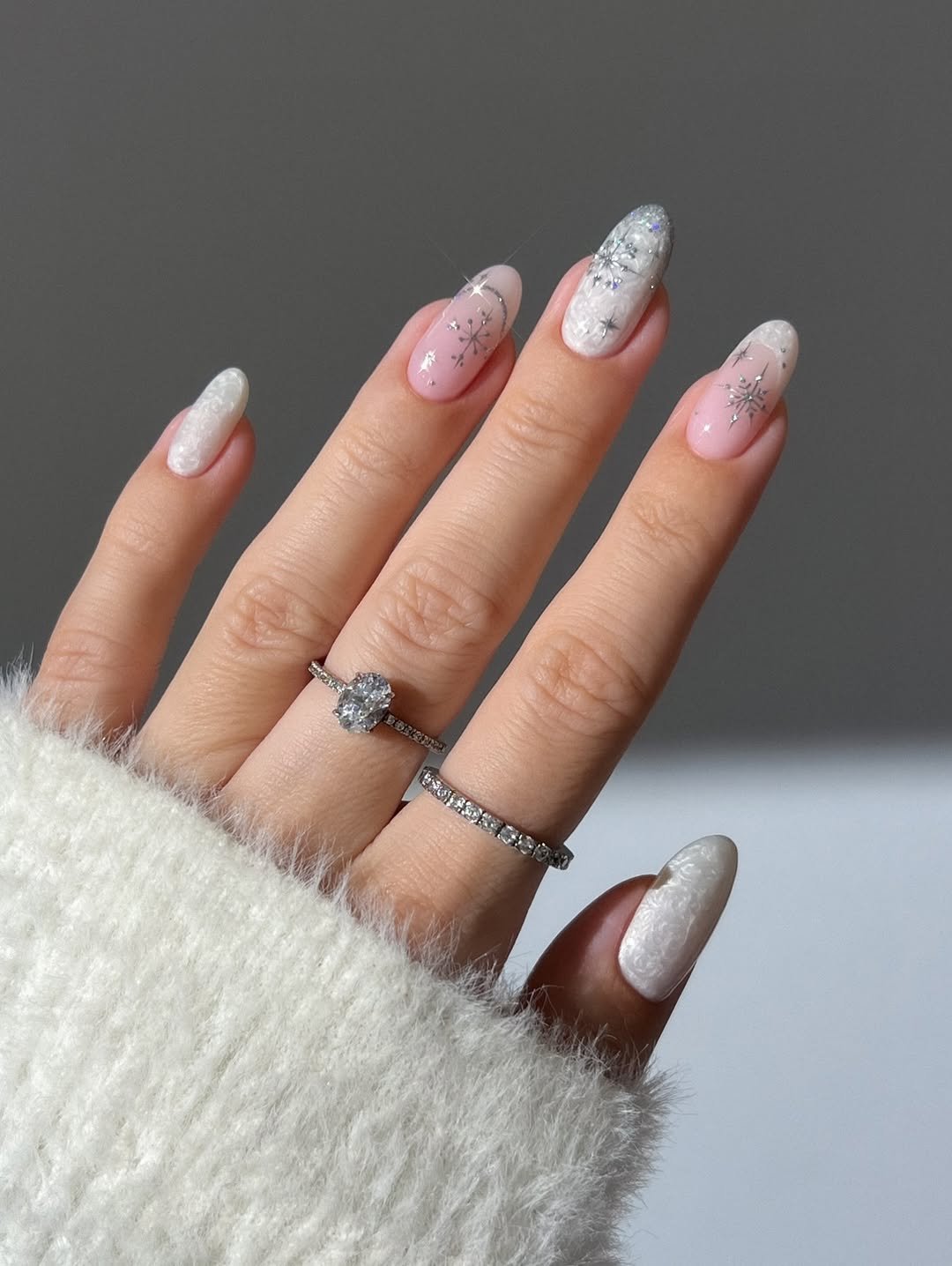 White nails , pearl nails, winter nails, silver nails, snowflake nails, spark nails, glitter nails, pink nude nails, french tip nails, oval diamond silver ring, silver eternity ring, pink nails, glass nails, cat eye gel polish, peppermint candy nails, holiday nails, Christmas nails, gingerbread nails, swirl nails, dainty gold ring with pink diamond, red nails, gold nails, sparkly nails, gradient nails, gold multi cut diamond ring, curved gold ring