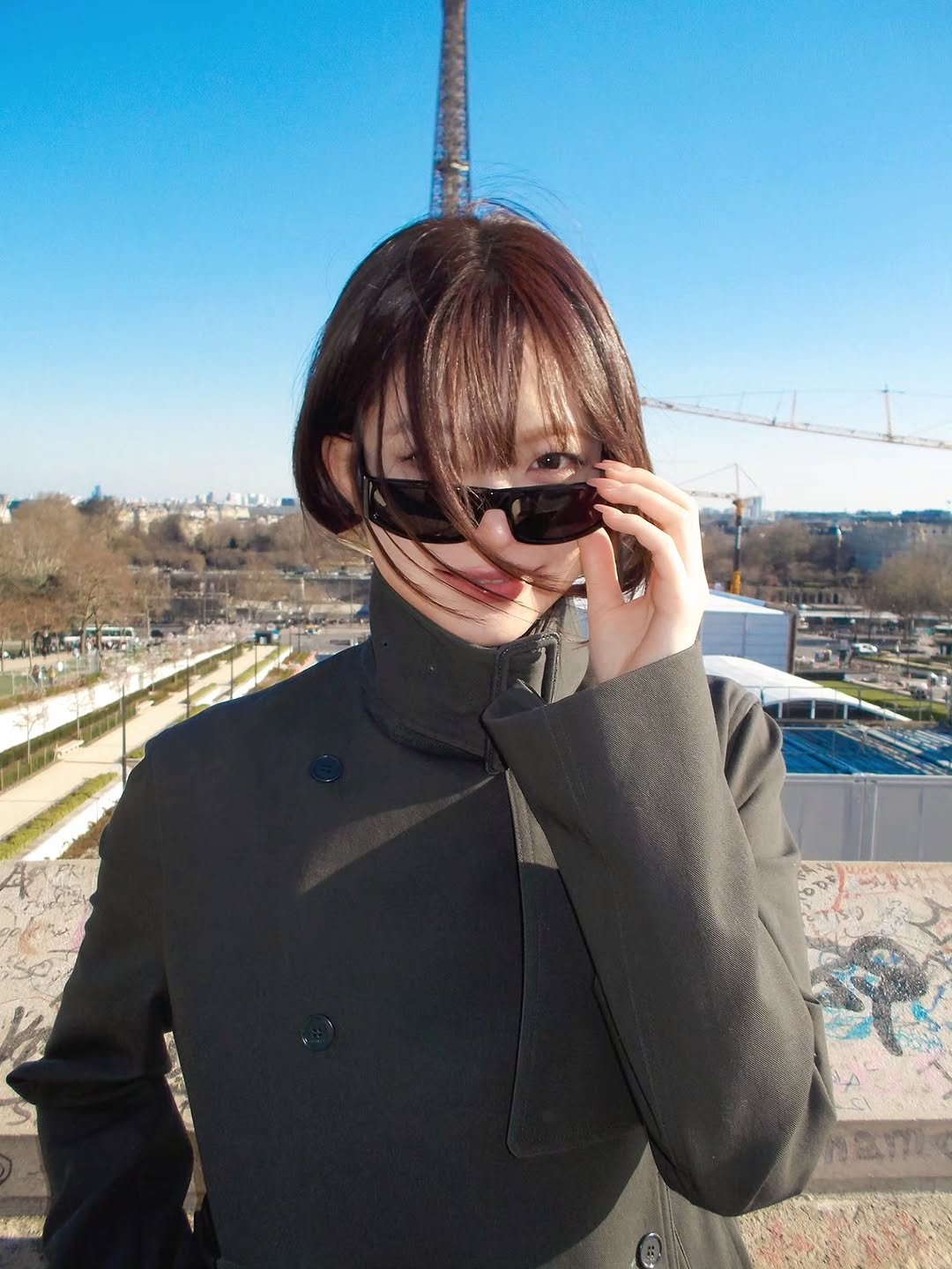 Photo shared by HONG EUNCHAE on March 05, 2026 tagging @courreges. May be an image of duffle coat, overcoat, beret, turtleneck, Sacré-Cœur, tower and text.