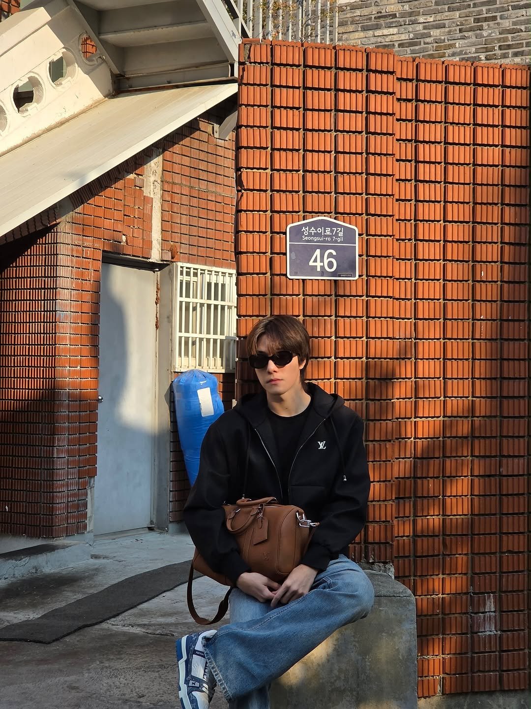 Photo shared by 「 Nani 」 on November 06, 2025 tagging @louisvuitton. May be an image of duffle coat, brick wall and text.