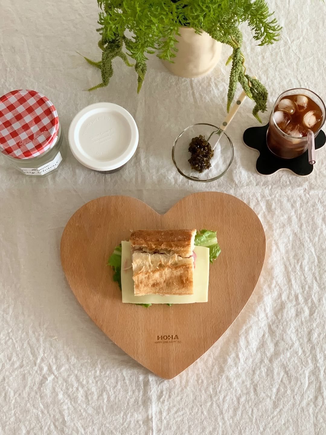 Photo shared by HOHA 호하 (前.살림취향집) on December 28, 2025 tagging @hoha.kr. May be an image of club sandwich, heart, baguette, croissant, preserves, placemat, napkin and text.