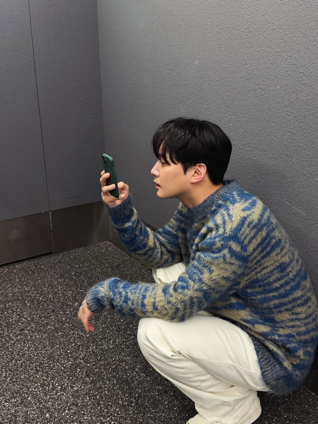 Photo by 권수현 on March 08, 2026. May be an image of duffle coat, phone, parka, sweater, turtleneck and text.