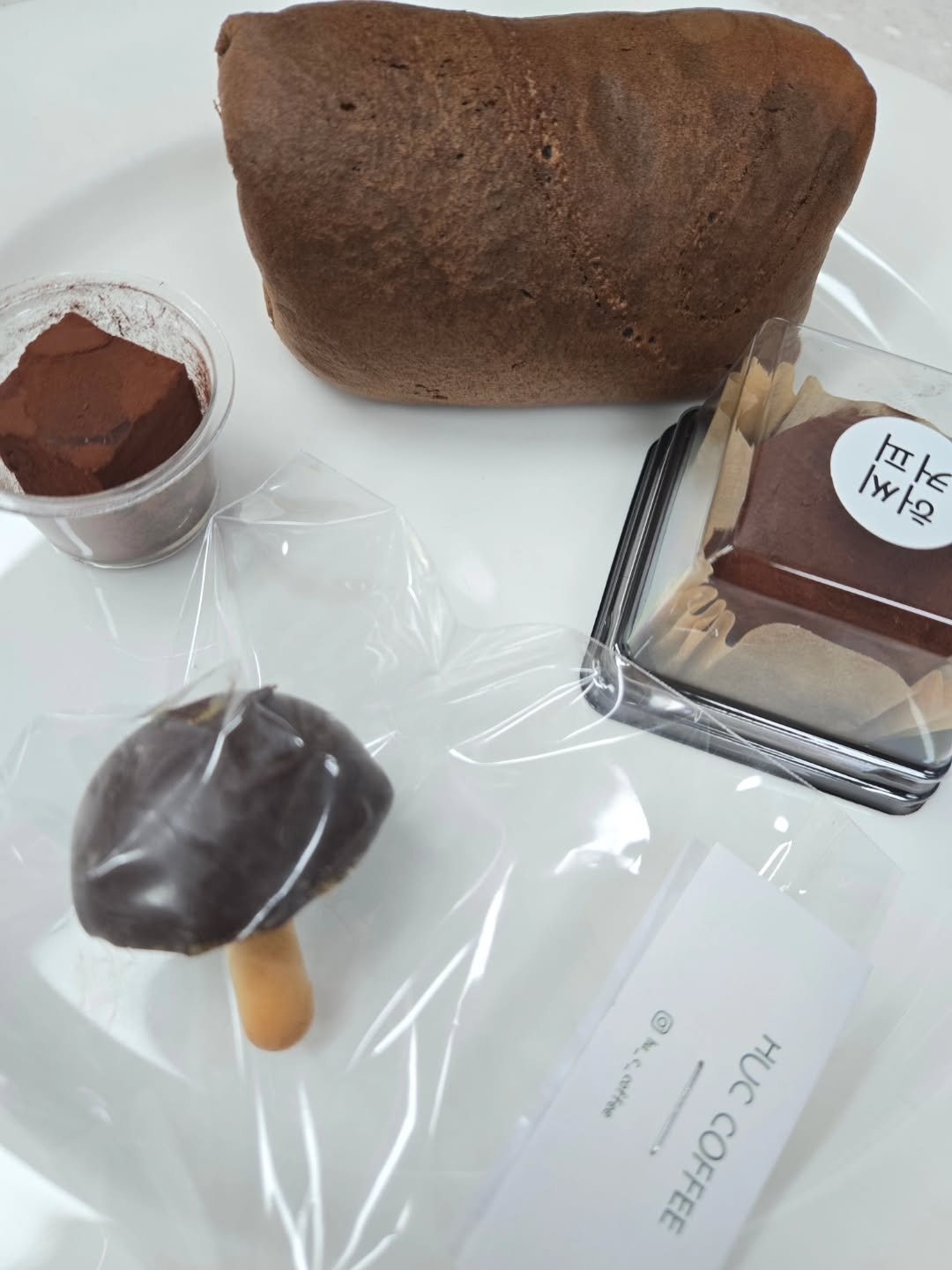 Photo by 강릉카페 강릉가볼만한곳 디저트카페 HU_C 허씨커피 on February 19, 2026. May be an image of chiffon cake, tiramisu, chocolate mousse, bread, truffle, eclair and text.