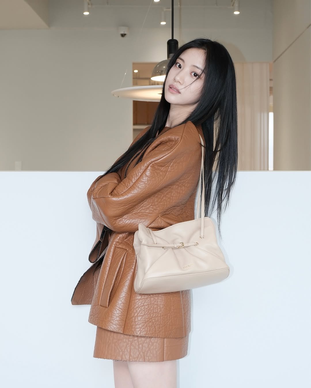 Photo shared by 홍화연 ••• Hong Hwayeon on October 26, 2025 tagging @prada. May be an image of one or more people, braids, leather, purse and text.