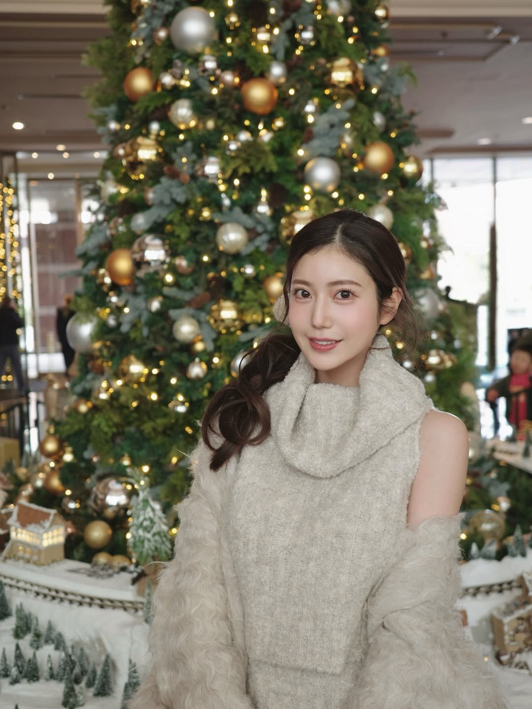 Photo by 阿部なつき on December 13, 2025. May be an image of one or more people, hair, christmas tree, fur, dress, turtleneck, parka and text.
