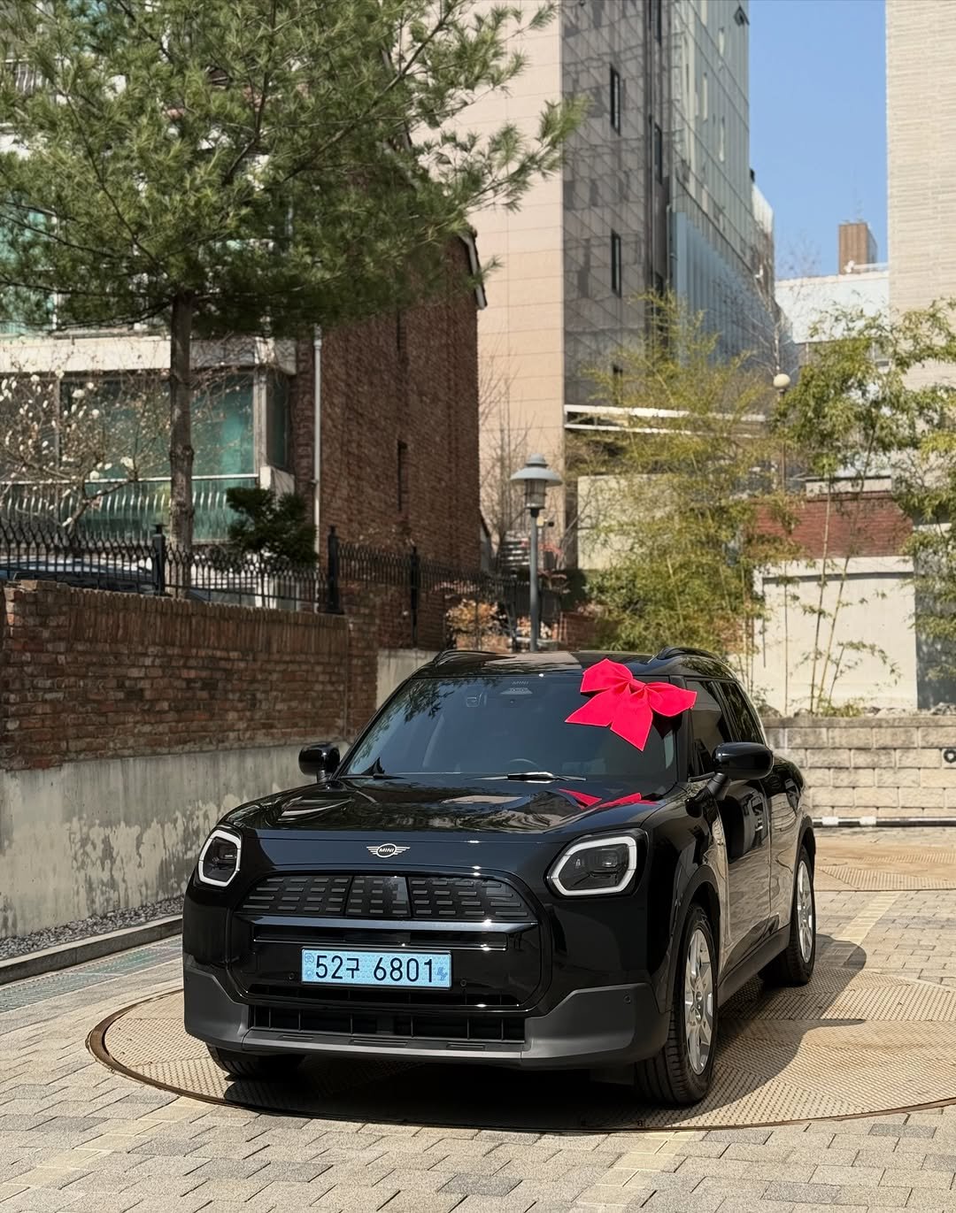 Photo shared by 미니쿠퍼 김은지팀장 on March 21, 2026 tagging @mini, @mini.korea.official, and @with._.mini. May be an image of wheel, sedan and text that says '5276801 6801 52구'.