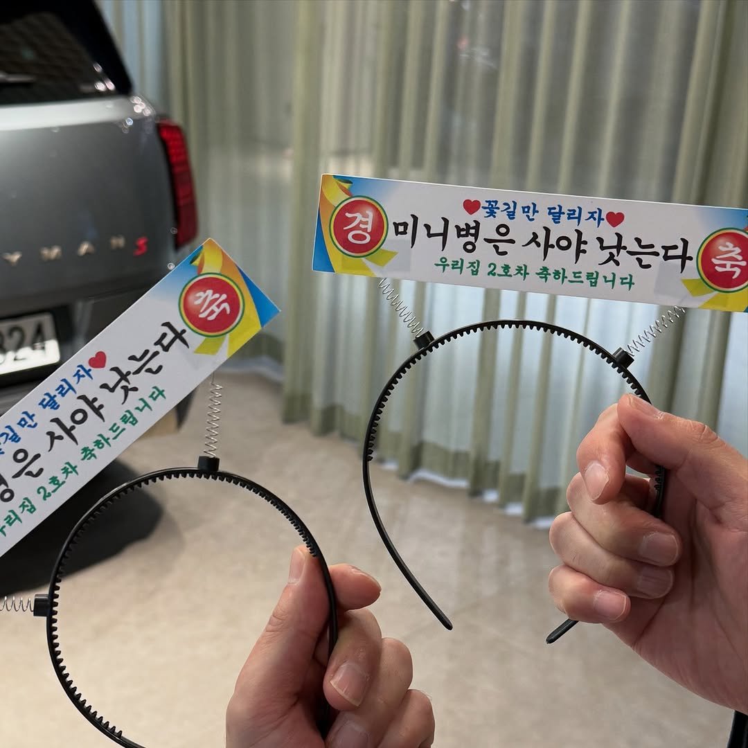 Photo shared by 미니쿠퍼 김은지팀장 on December 11, 2025 tagging @mini, @mini.korea.official, and @with._.mini. May be an image of car, hairpin and text that says '경 미니병 꽃길만 달리자 대니병은사야 미니병은사야낫는다 니 사야 우리집2호차축하드립니다 낫는다 축 우리집 2호차 축하드립니다 은사야낫는다 く 축 길만달리자 은사야 달리자 낫는다 만 사야 축하드립니다 리집 집 은 2호차'.