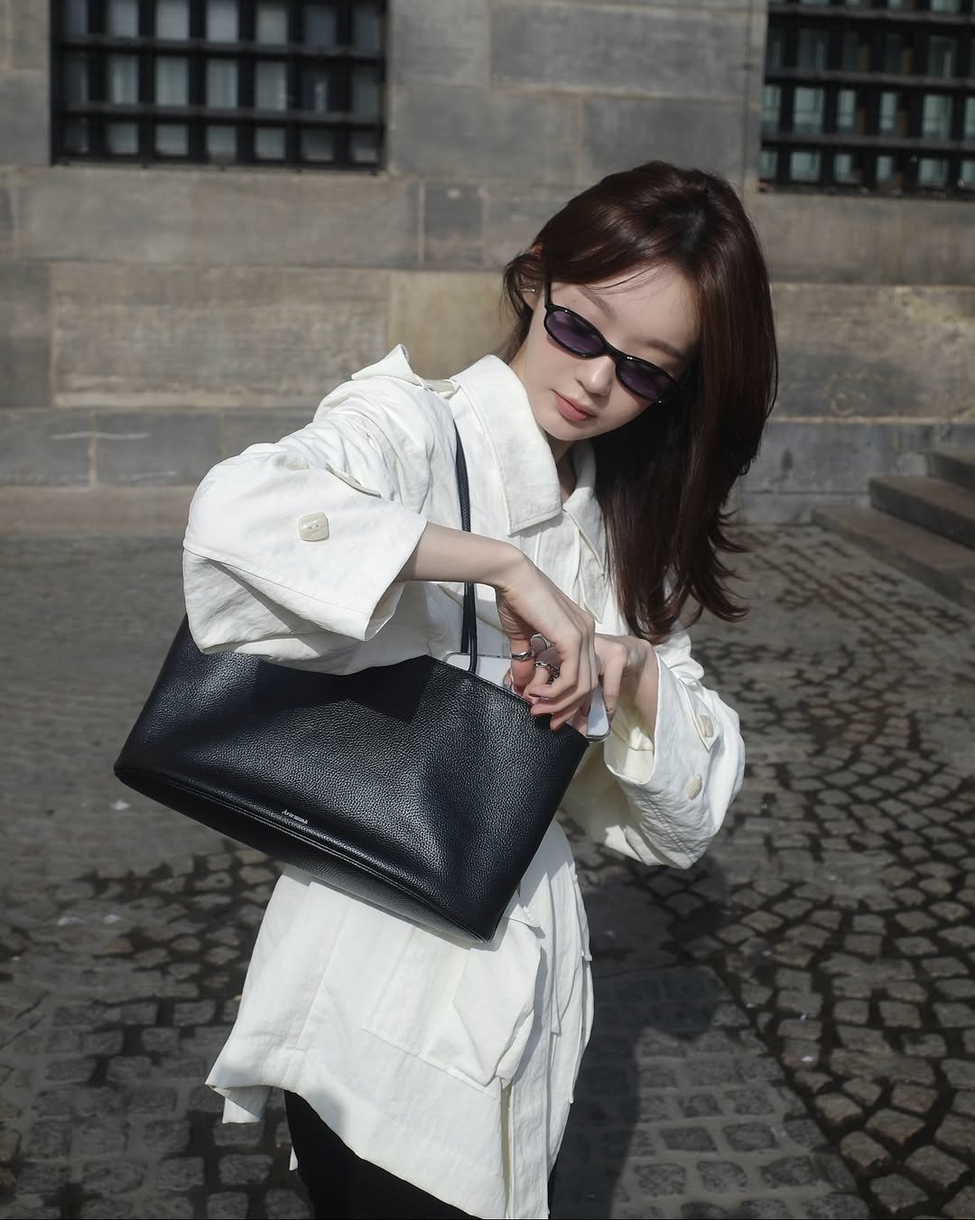 Photo shared by 강민경 (행동파) on September 02, 2025 tagging @aviemuah. May be an image of 1 person, purse, briefcase, clutch and text.