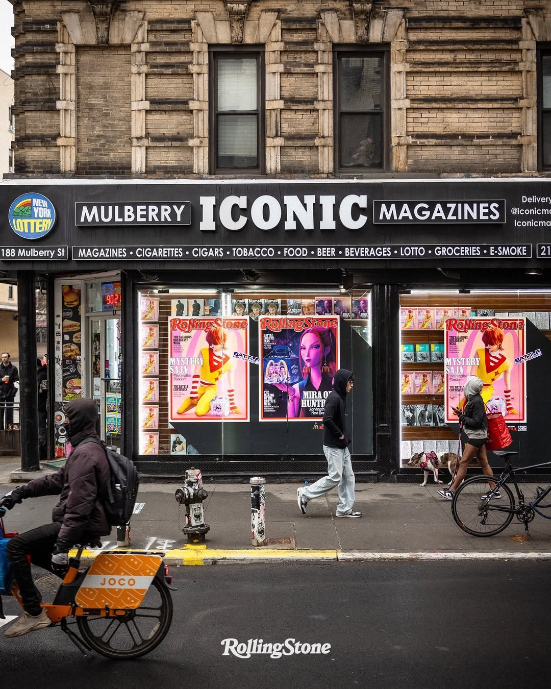 Photo shared by Rolling Stone on April 03, 2026 tagging @mcdonalds, @netflix, and @iconicmagazines. May be an image of signboard, street, newsstand, buildings and text that says 'UITER 188 Mulberry St Deliven MULBERRY ICONIC MAGAZINES Slconicme Iconicma MAGAZINES CIGARETTES CIGARS TOBACCO FOOD BEER BEVERAGES LOTTO GROCERIES E-SMOKE 2 만스감 WYSTERT . 금콜점 MESTERY MIRAO HUNTF បនព 品載 監 JOCO RollingStone'.