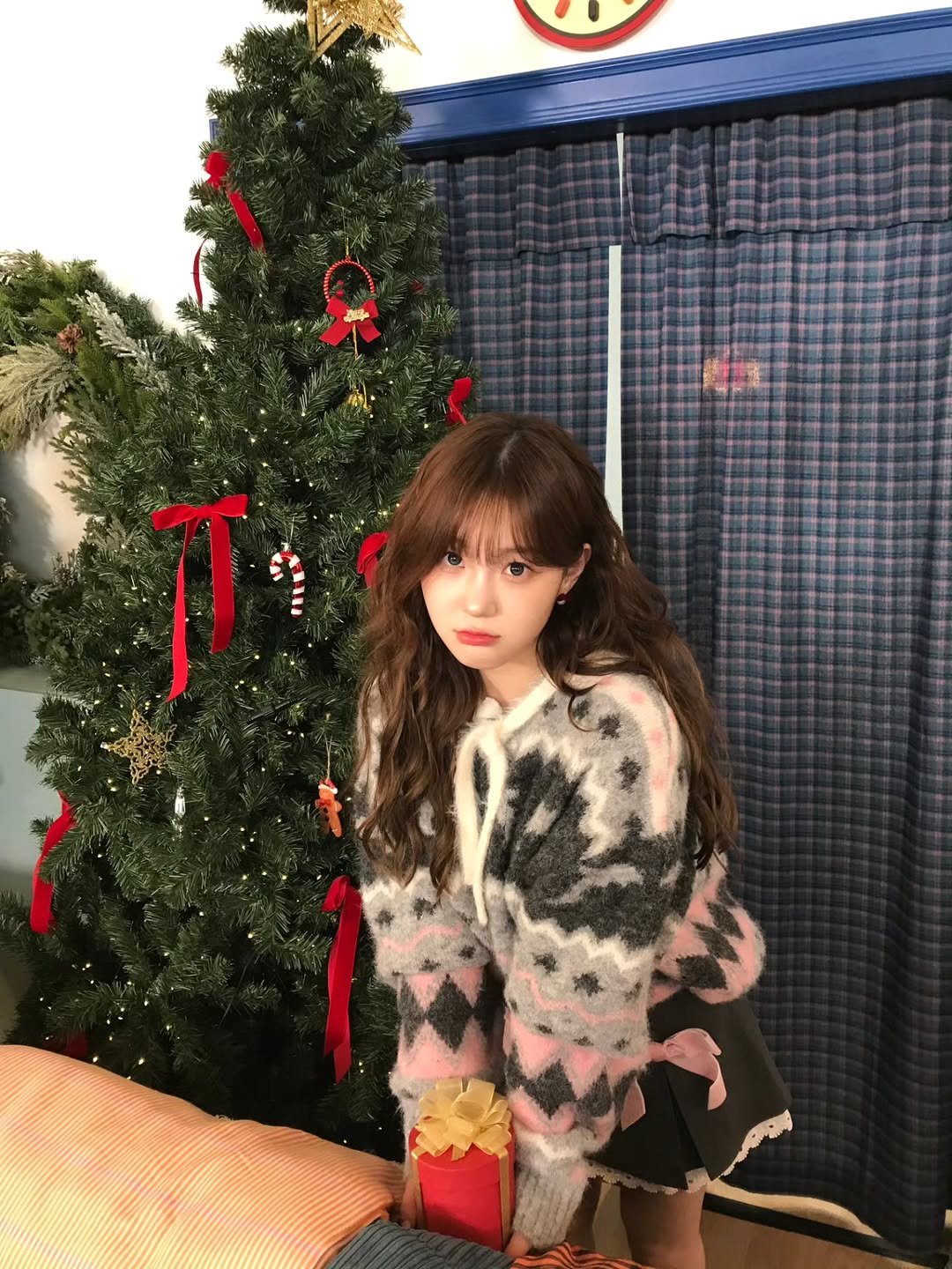 Photo by 김채현 KIM CHAEHYUN on December 25, 2025. May be an image of one or more people, hair, christmas tree, tinsel, sweater and text.