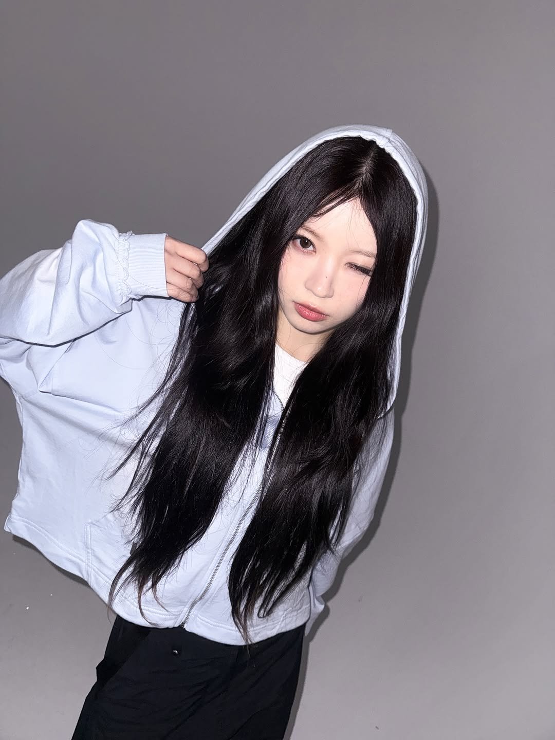 Photo shared by ILLIT 아일릿 on March 29, 2026 tagging @superdrykor. May be an image of one or more people, hair, top, parka, cloak and text.