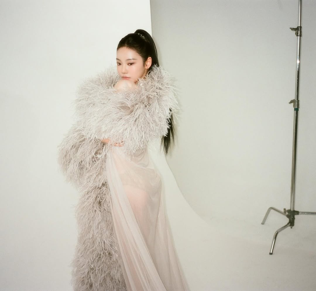 Photo by NINGNING on February 19, 2026. May be an image of one or more people, makeup, hair, goosedown coat, fur coat, gown, dress, shawl and text.