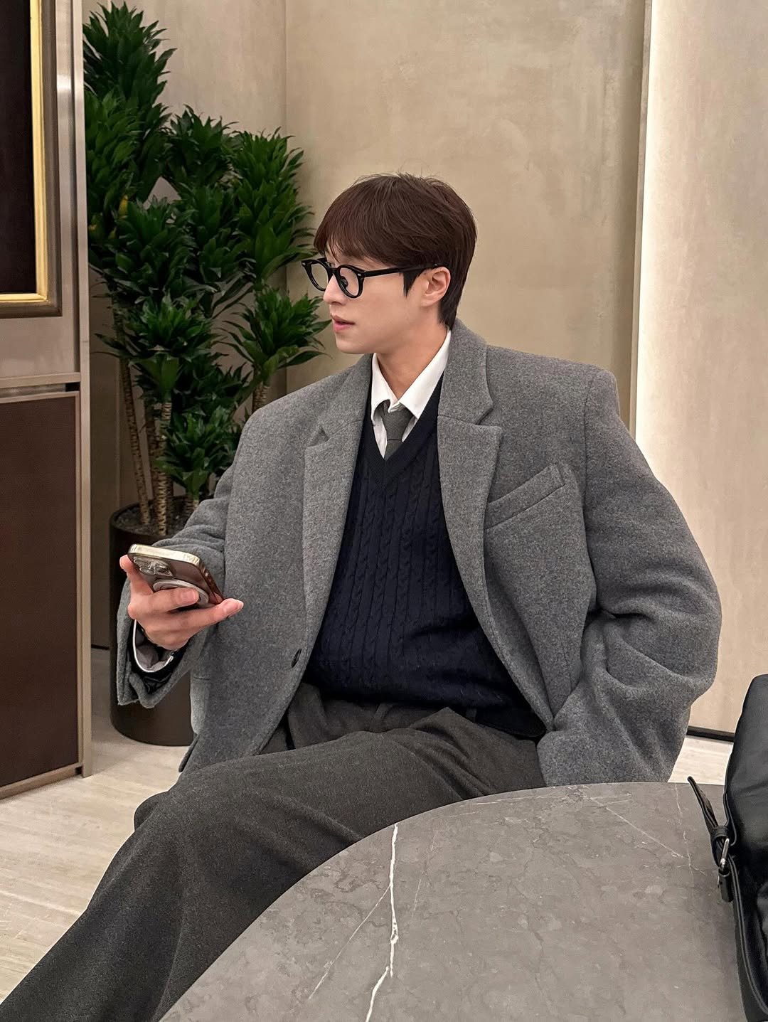 Photo by 인호ㅣ어스모어 on December 10, 2025. May be an image of smoking, duffle coat, overcoat, wingtip shoes, eyeglasses, cigarette, suit, turtleneck and text.