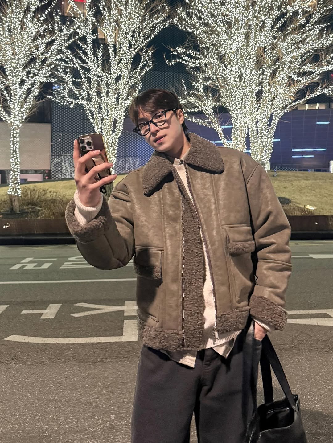 Photo by 인호ㅣ어스모어 on January 05, 2026. May be an image of duffle coat, overcoat, phone, goosedown coat, jacket, parka and text.