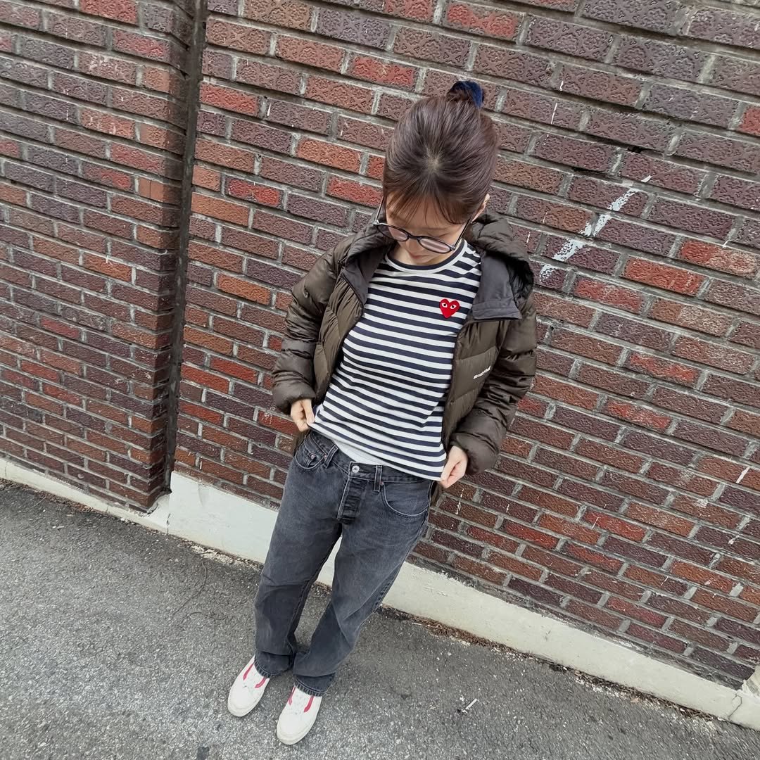 Photo by 인팁걸 on March 01, 2026. May be an image of baby, duffle coat, jacket, brick wall and text.