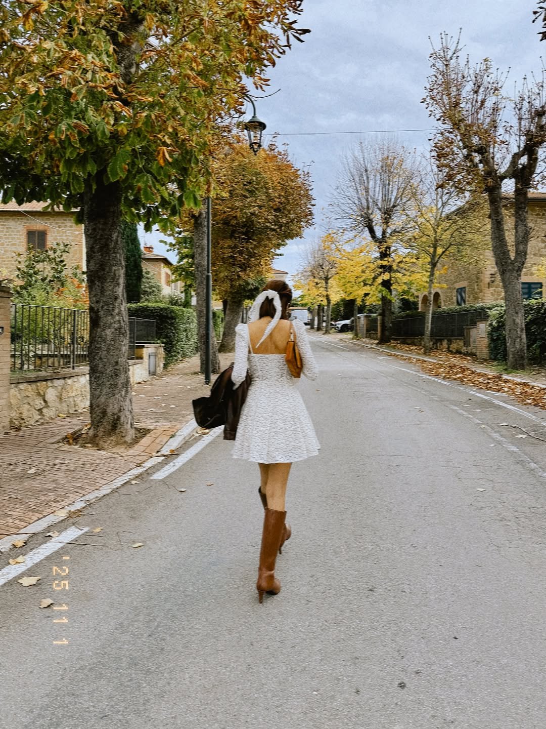 Photo by Isha Borah on October 31, 2025. May be an image of parasol, dress, road, street and text.