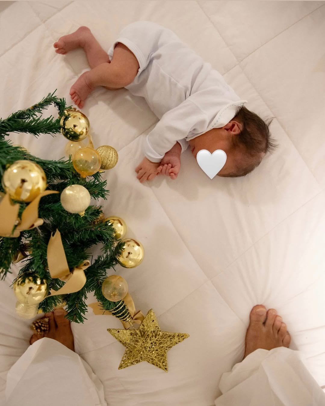 Photo by Italo Ferreira on December 24, 2025. May be an image of baby, sleeping, christmas tree, baby bed and text.