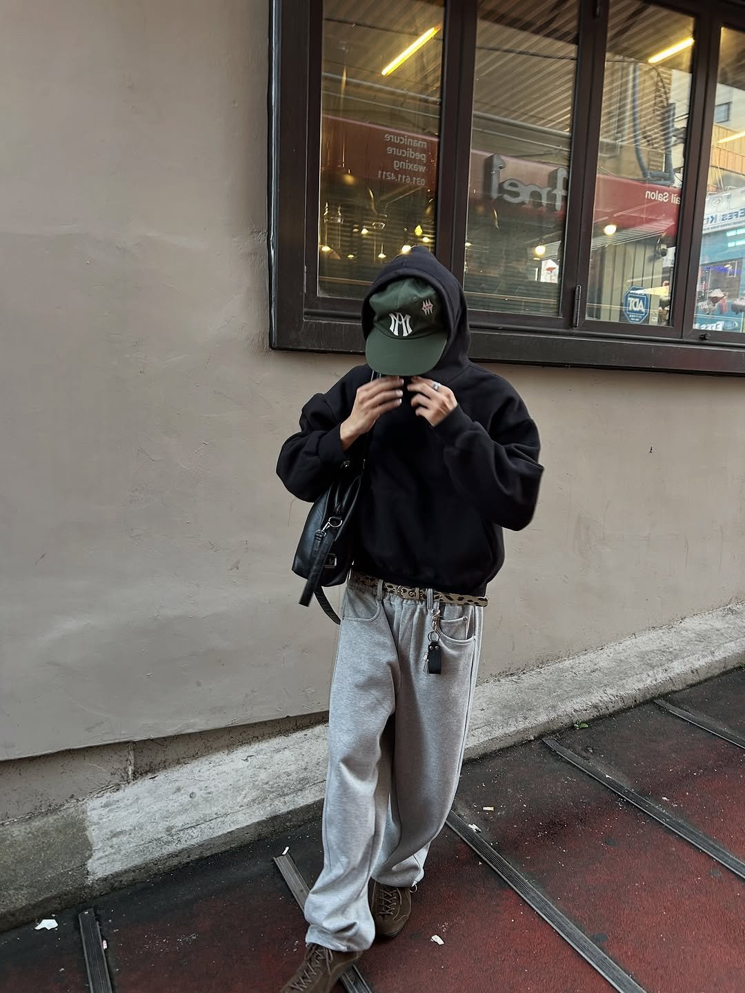 Photo by 정재훈 | CAON on September 29, 2025. May be an image of 1 person, smoking, duffle coat, face mask, sweatpants, sweatsuit, parka, street and text.