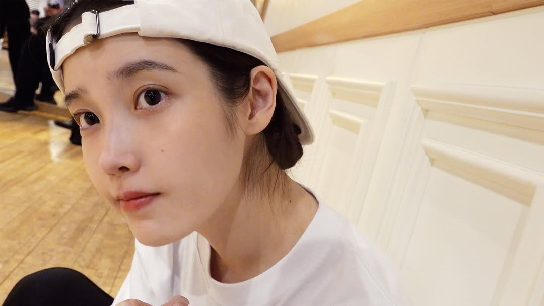 Photo shared by 아이유(IU) on April 28, 2026 tagging @dlwlrma. May be an image of one or more people, hair, hat and text.