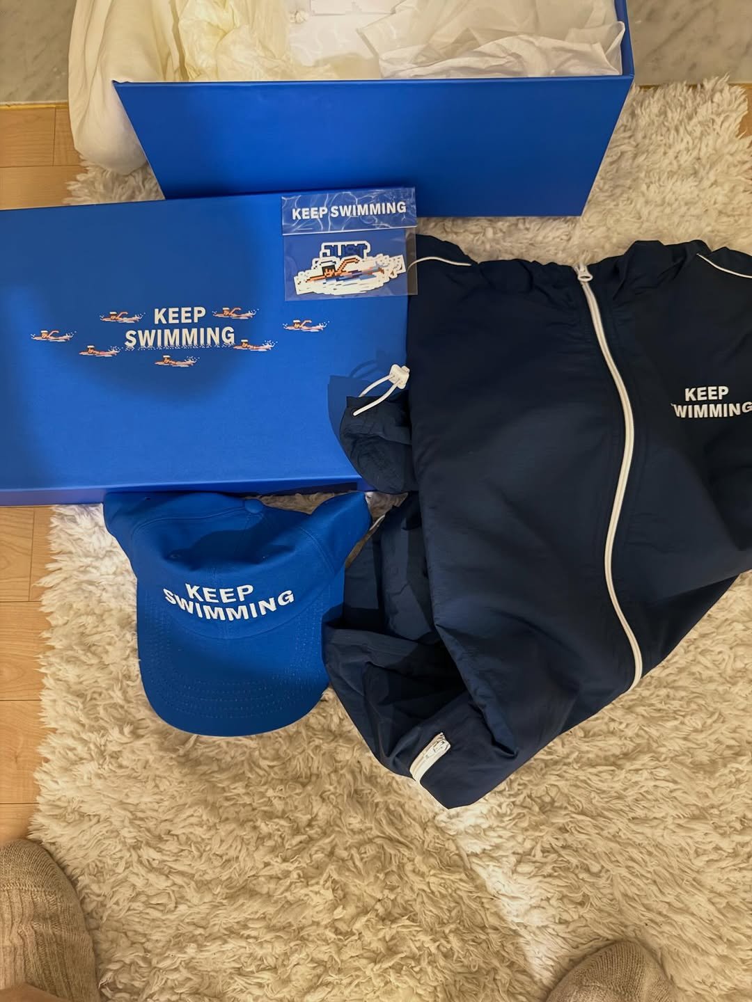 Photo by 정재형 on April 08, 2026. May be an image of ‎raincoat, box, fleece, sportswear, sweatsuit, parka and ‎text that says '‎KEEPSWIMMING SWIMMING KEEP KEEP KEEP ک SWIMMING ح 黒 KEEP WIMMING SWIMMING NIMMIN WKEEPN KEEP‎'‎‎.