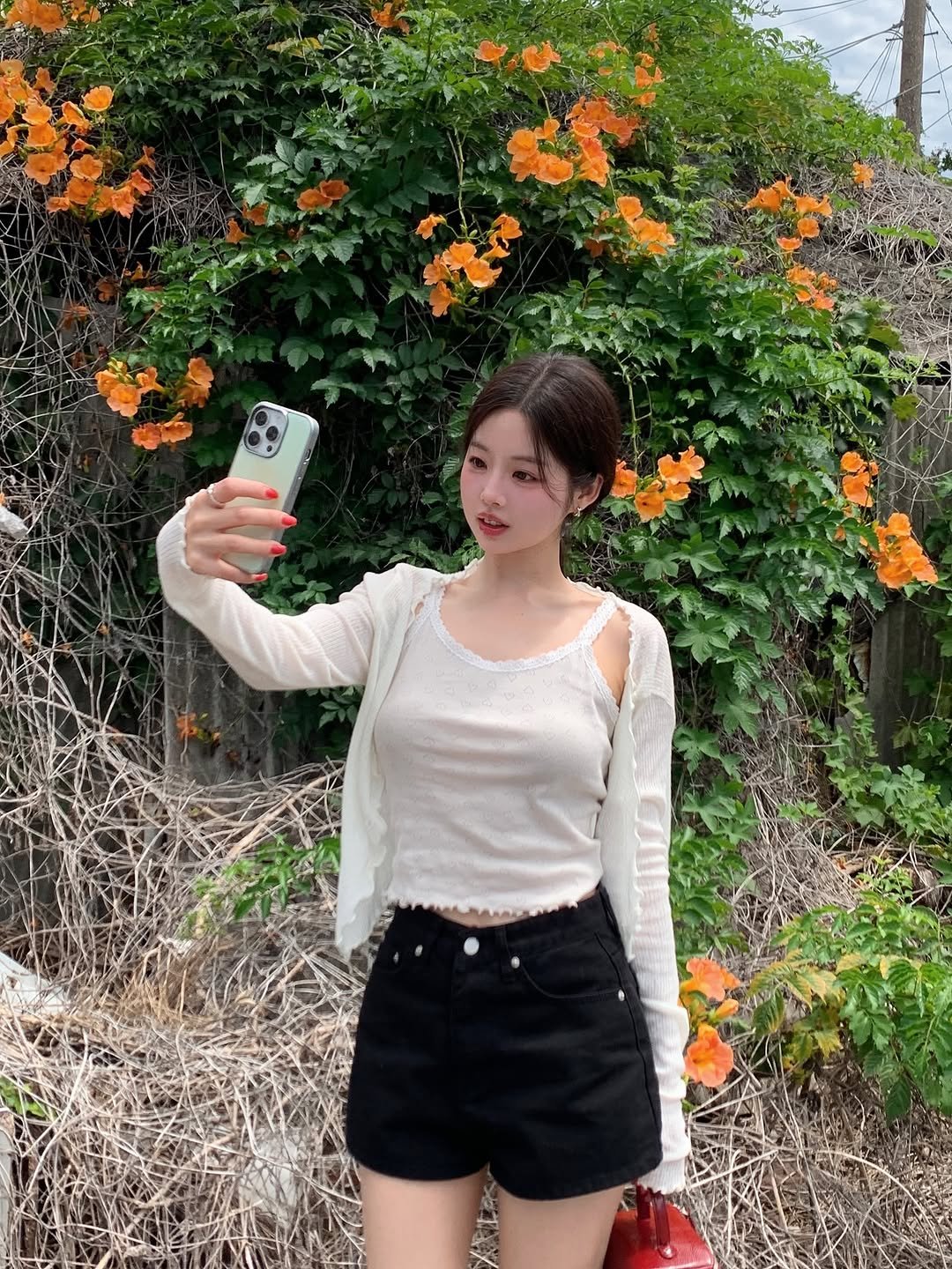 Photo by 지원 on July 24, 2025. May be an image of 1 person, phone and flower.