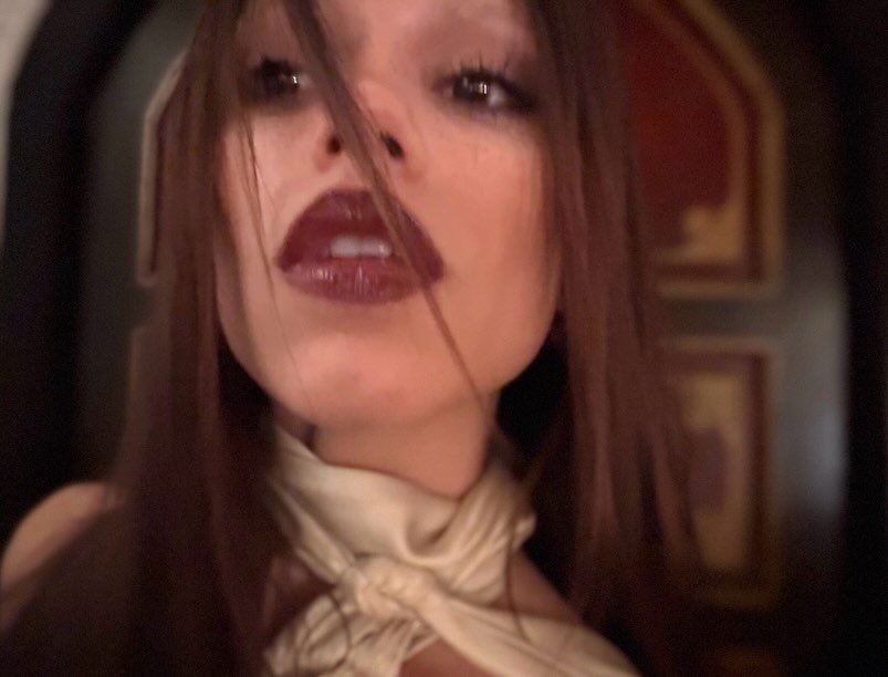 Photo by Jenna Ortega on December 19, 2025. May be a selfie of one or more people, lipstick, makeup, turtleneck, neckwear and text.