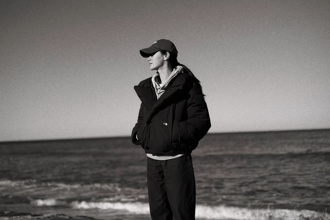Photo by 전여빈 Yeobeen Jeon on February 17, 2026. May be a black-and-white image of one or more people, people standing, parka, ocean, beach and text.