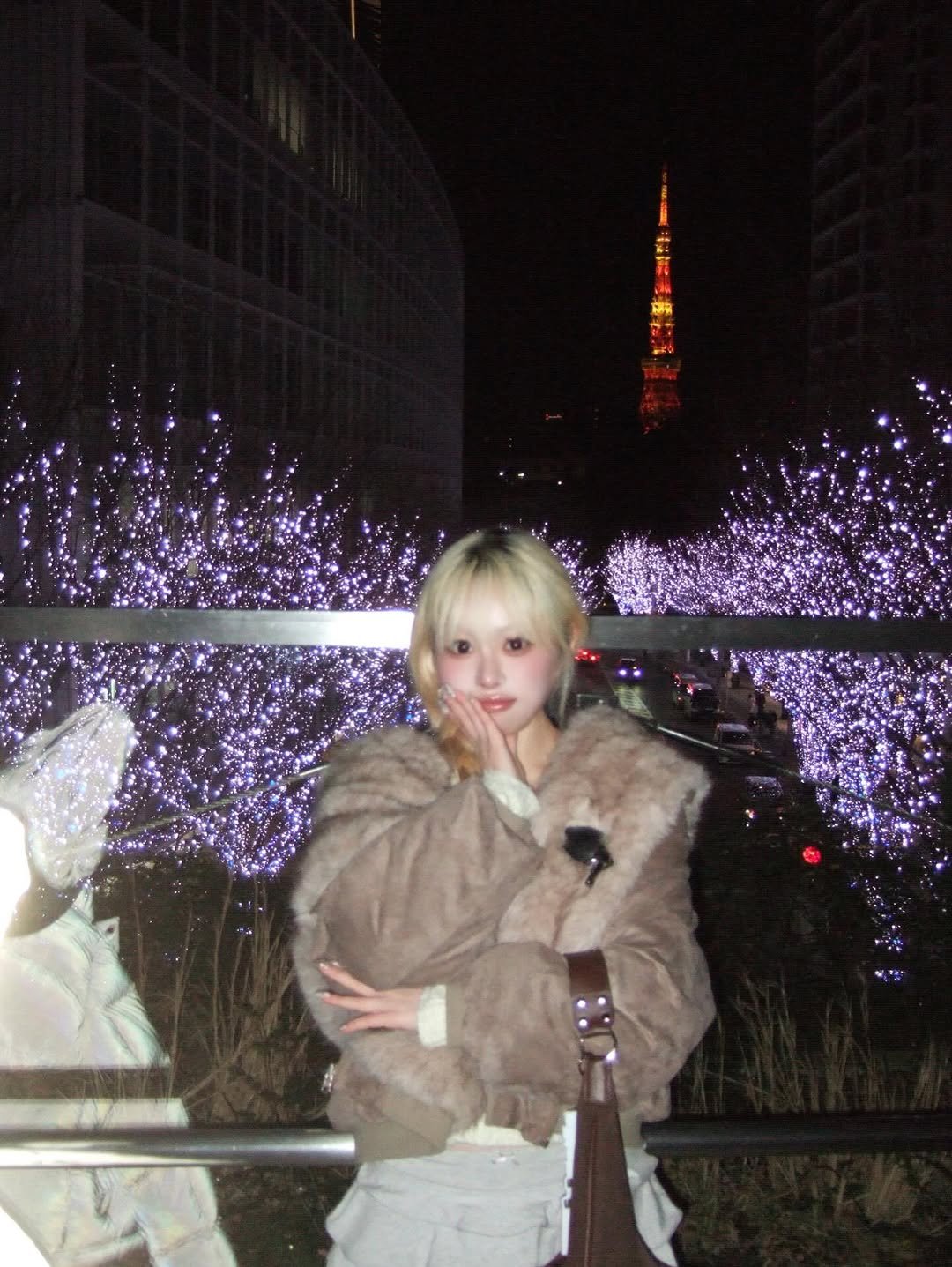Photo shared by 유정 YUJEONG on December 31, 2025 tagging @luvistrue_official, @beglowny, and @yeomim. May be an image of one or more people, blonde hair, duffle coat, fur, parka, cigarette, Tokyo Tower, night and text.