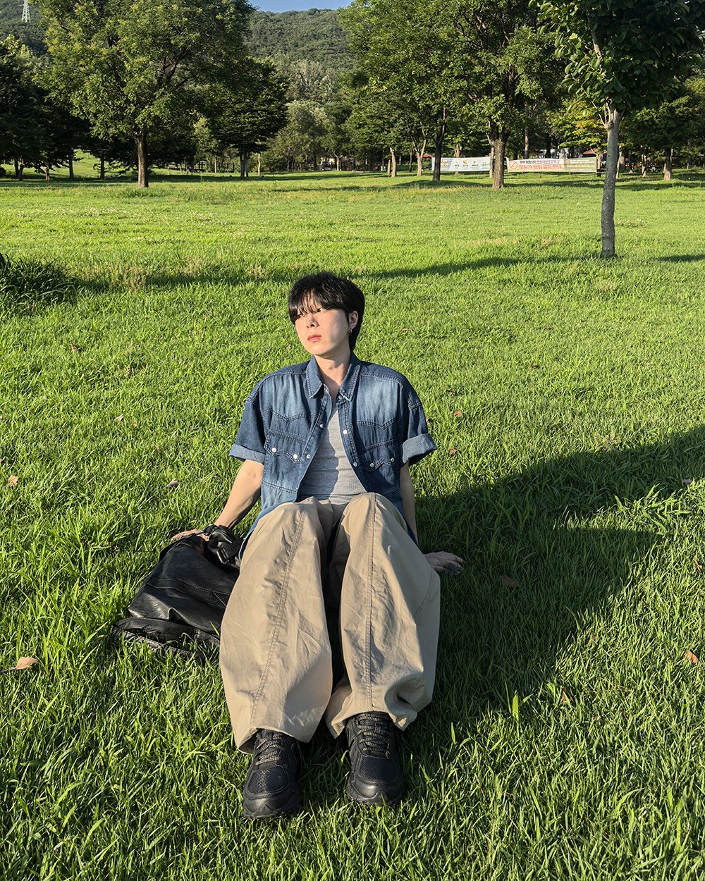 Photo by 지금JIIGEUM🌿 on July 28, 2025. May be an image of 1 person, grass, picnic, park and text.