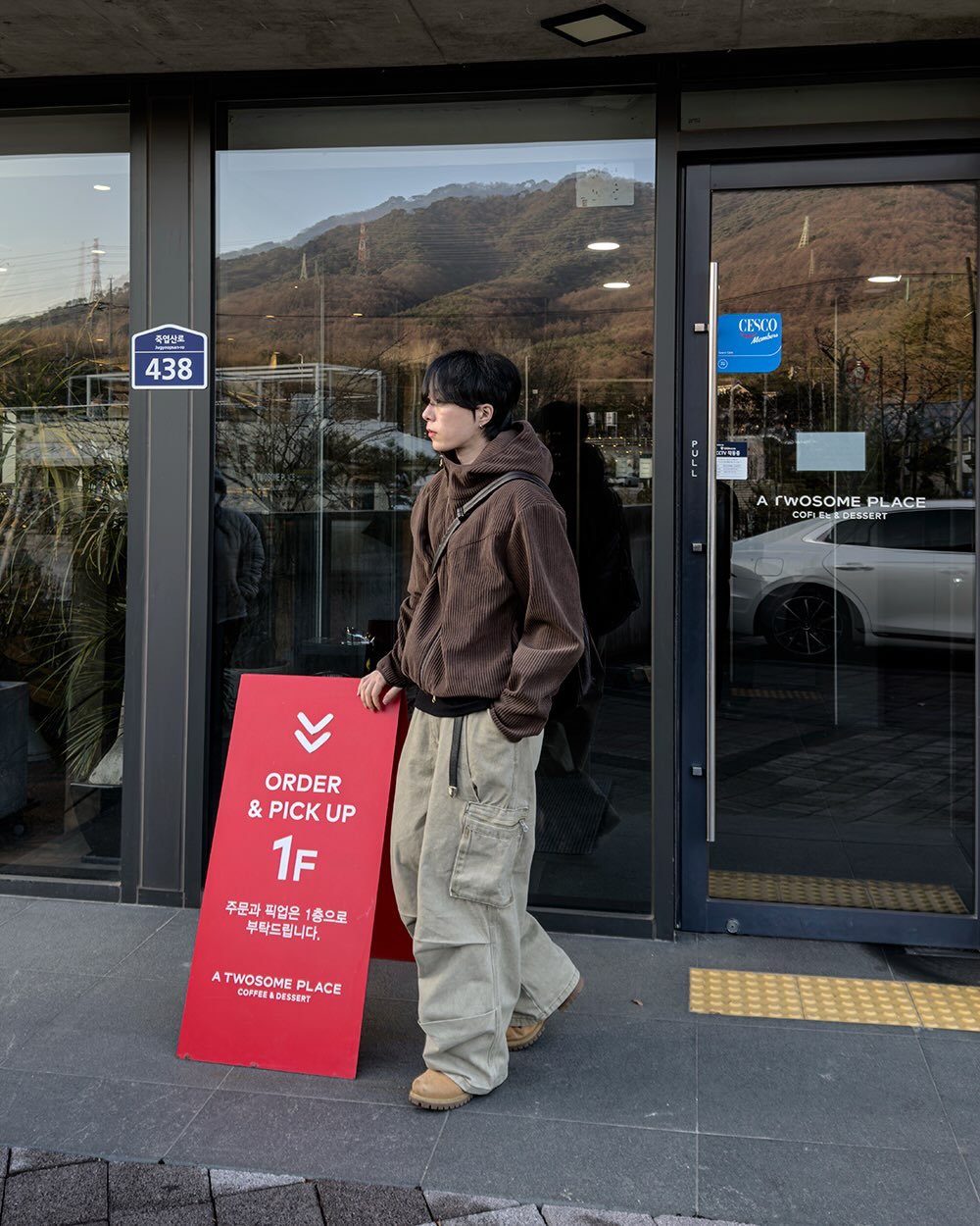 Photo by 지금JIIGEUM❄️ on December 17, 2025. May be an image of one or more people, people standing, duffle coat, display case, signboard, parka, street and text that says '즉별산로 438 CESCO Jup ዘዋ 無印者 A A rWOSOME PLACE COLLE CORENEDESSERT ATWOSOMEPLACE MEDESSERT COOL ORDER & PICK UP 1F 주문과 1층으로 무탁드립니다. ATW A TWOSOME PLACE ATWOSOMEPLACE ORFIRA DESSERT'.