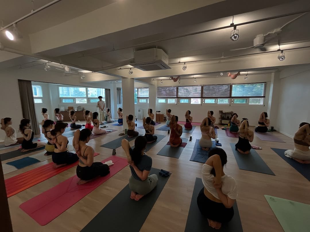 Photo shared by 성신여대 요가 | 또, 요가 on August 15, 2025 tagging @jihyuni.yoga, and @likethis_yoga. May be an image of 17 people, people practicing yoga, mat and text.