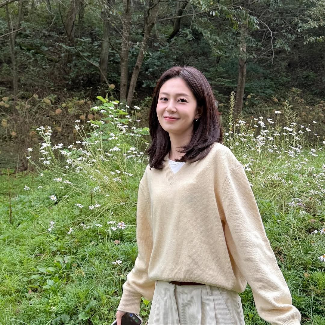 Photo shared by Baek jinhee💕 on October 20, 2025 tagging @pebblem_official. May be an image of turtleneck, top, baby's-breath, white lily, outdoors and text.