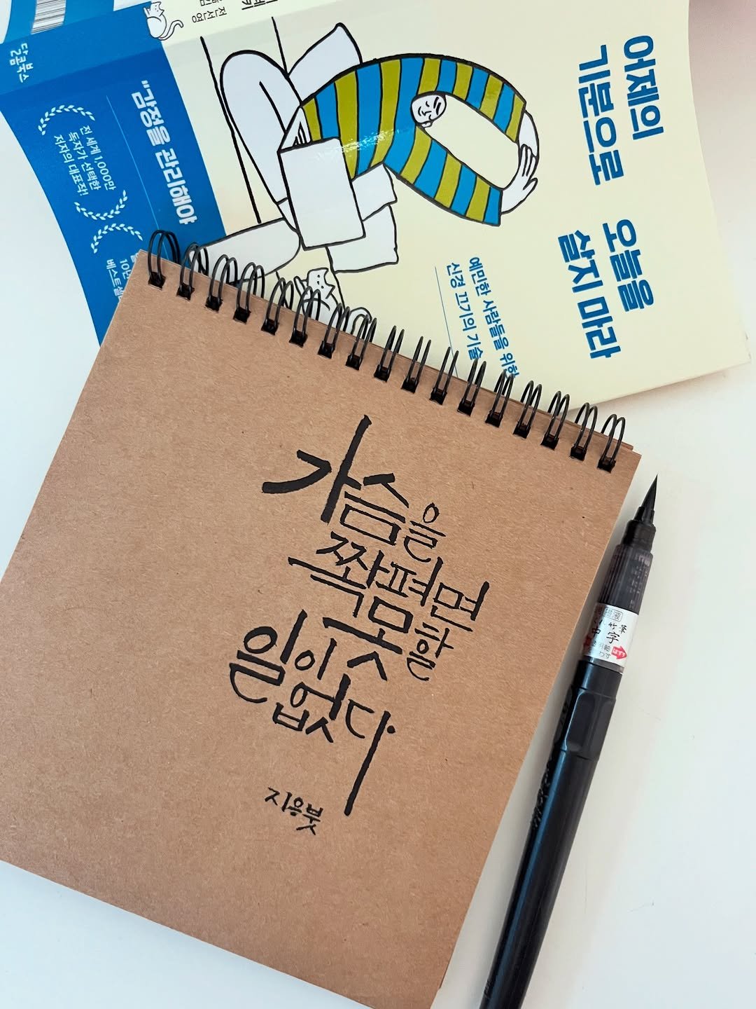 Photo by 신지우캘리그라피/지우글씨 on December 27, 2025. May be a doodle of ‎diary, pencil, pen, pencil case, sketch, book, clipboard and ‎text that says '‎bE ផងង01ង Nn 마워 17 저자의 독자가 도자가 저세게 대표장! 1,000막 "감정을관리해야 "감정을 관리해야 기분으로 기분으로 제마 살지 0 오늘을 to 마라 保マ 刺一合四 ЛC 무기기원과 olcu 롱름을스 가 작퍼며 시아다묘 일없다 דולבן 지음부 空‎'‎‎.