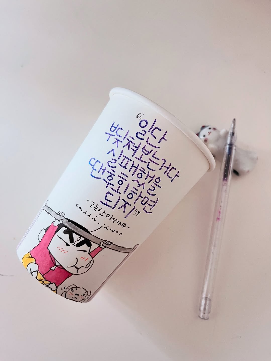 Photo by 신지우캘리그라피/지우글씨 on December 26, 2025. May be pop art of cup, pen, water bottle and text.