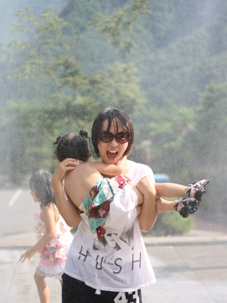 Photo by 이지영 on June 15, 2025. May be an image of child, sprinkler, umbrella, park, fountain and text.