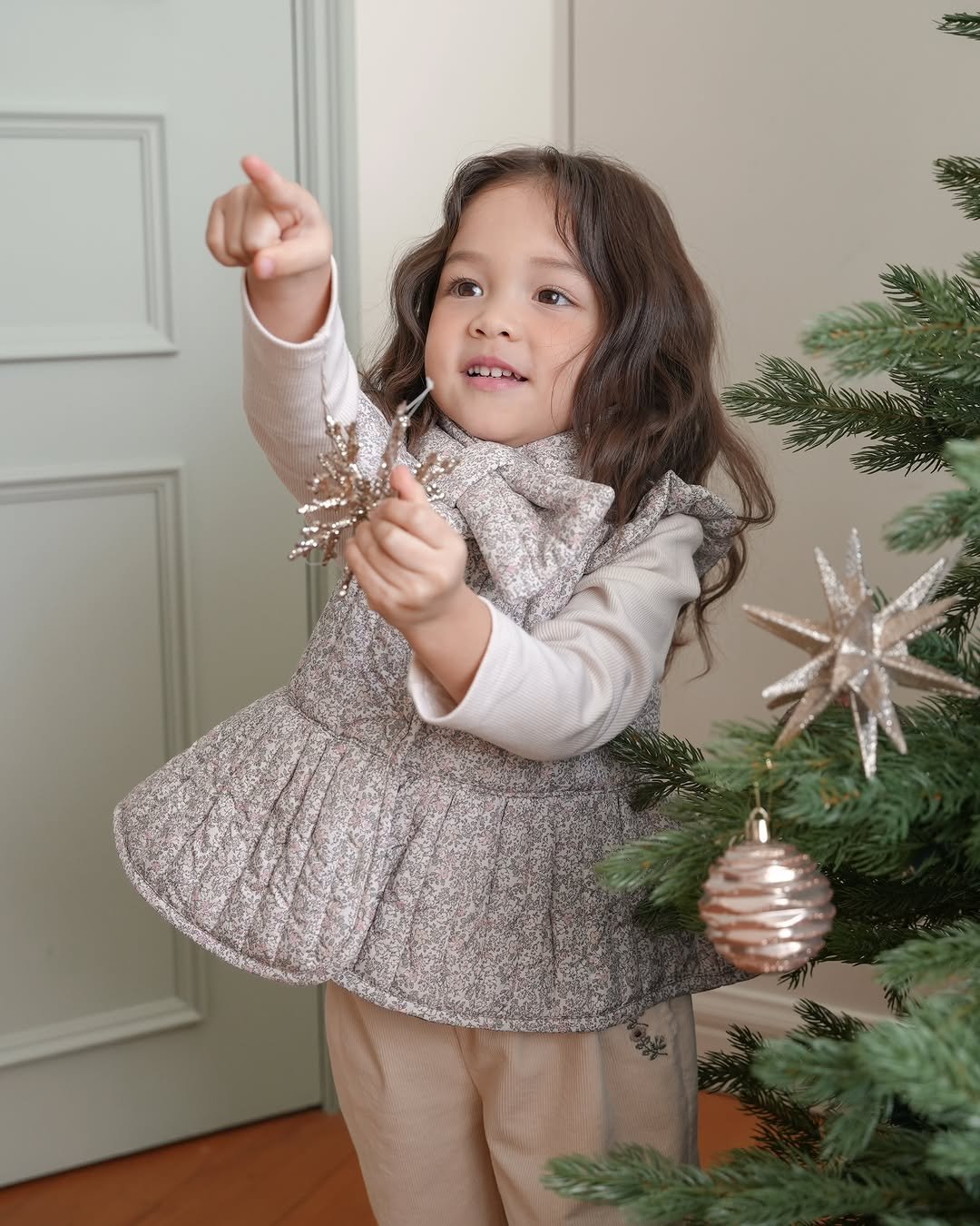 Photo by 제이라스 on December 09, 2025. May be an image of baby, christmas tree, overskirt, tinsel, pinecone and text.
