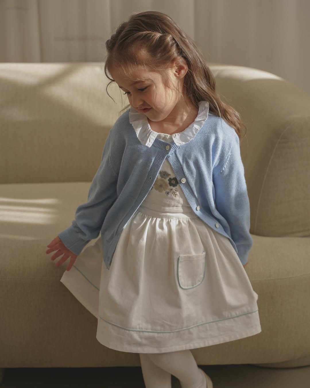 Photo by 제이라스 on February 10, 2026. May be an image of child, cardigan, dress and text.