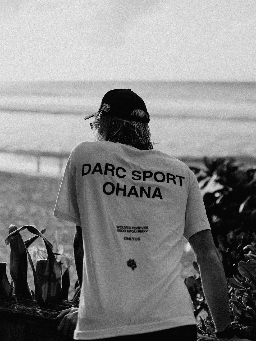 Photo shared by John Mel on April 16, 2026 tagging @darcsportathletics. May be a black-and-white image of skateboard, surfboard, wetsuit, sportswear, water, ocean, beach and text that says 'ΟΗΑΝΑ ARCHANA SPORT SPORT'.