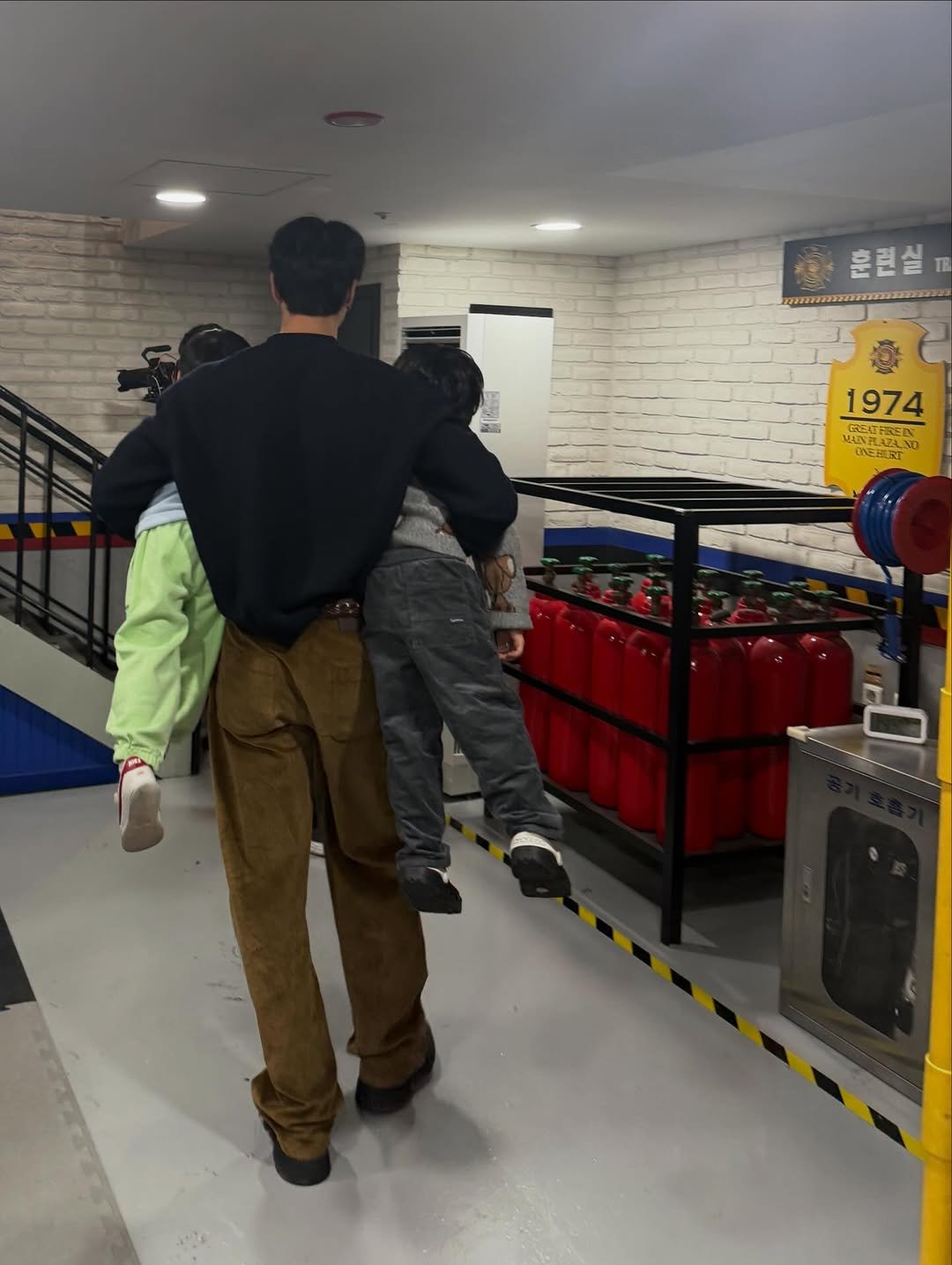 Photo by Johnny Suh on December 18, 2025. May be an image of one or more people, people standing, skateboard, duffle coat, parka and sling.