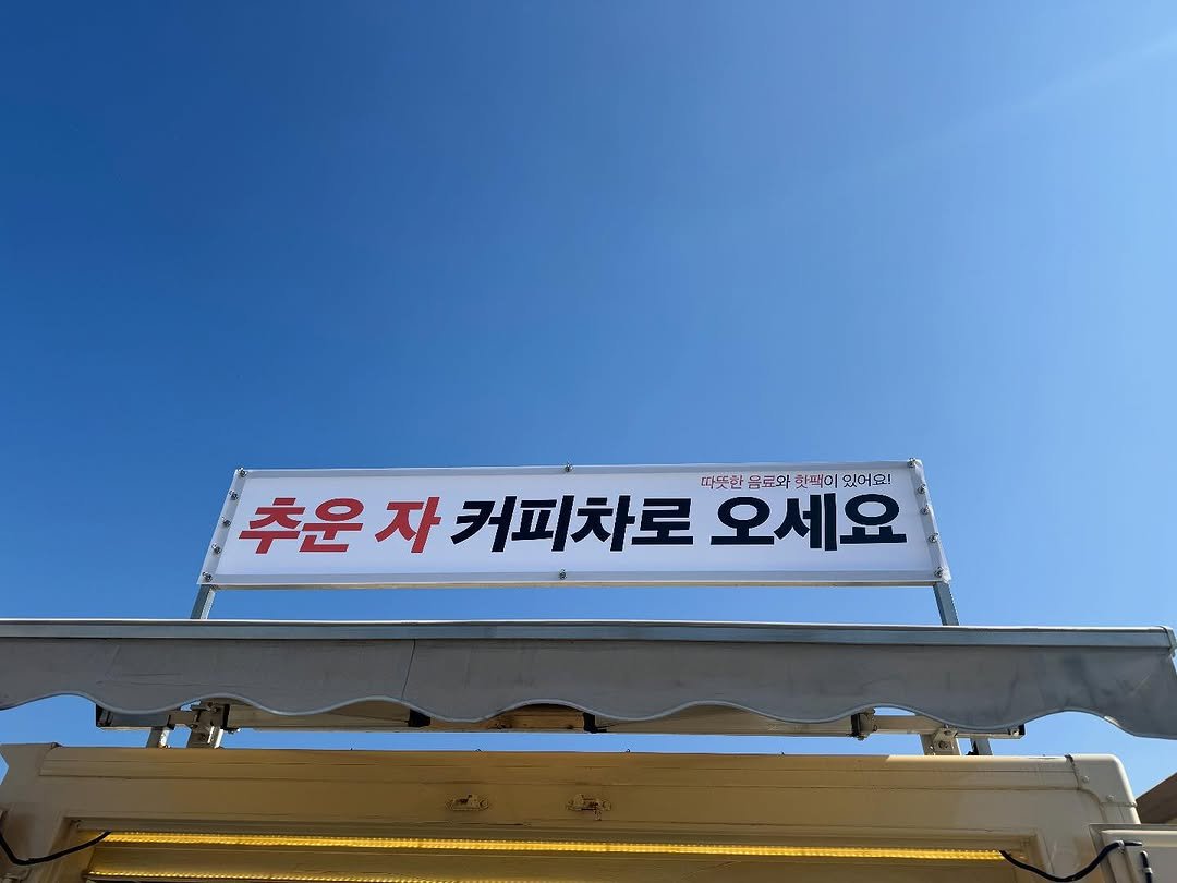 Photo by 차주영 Cha Joo Young on November 12, 2025. May be an image of signboard and text that says '추운자커피차로오서 때뜻한음료회회패이있어오! 따뜻한 음료와 핫패이 있어요! 추운 자 커피차로 오세요'.