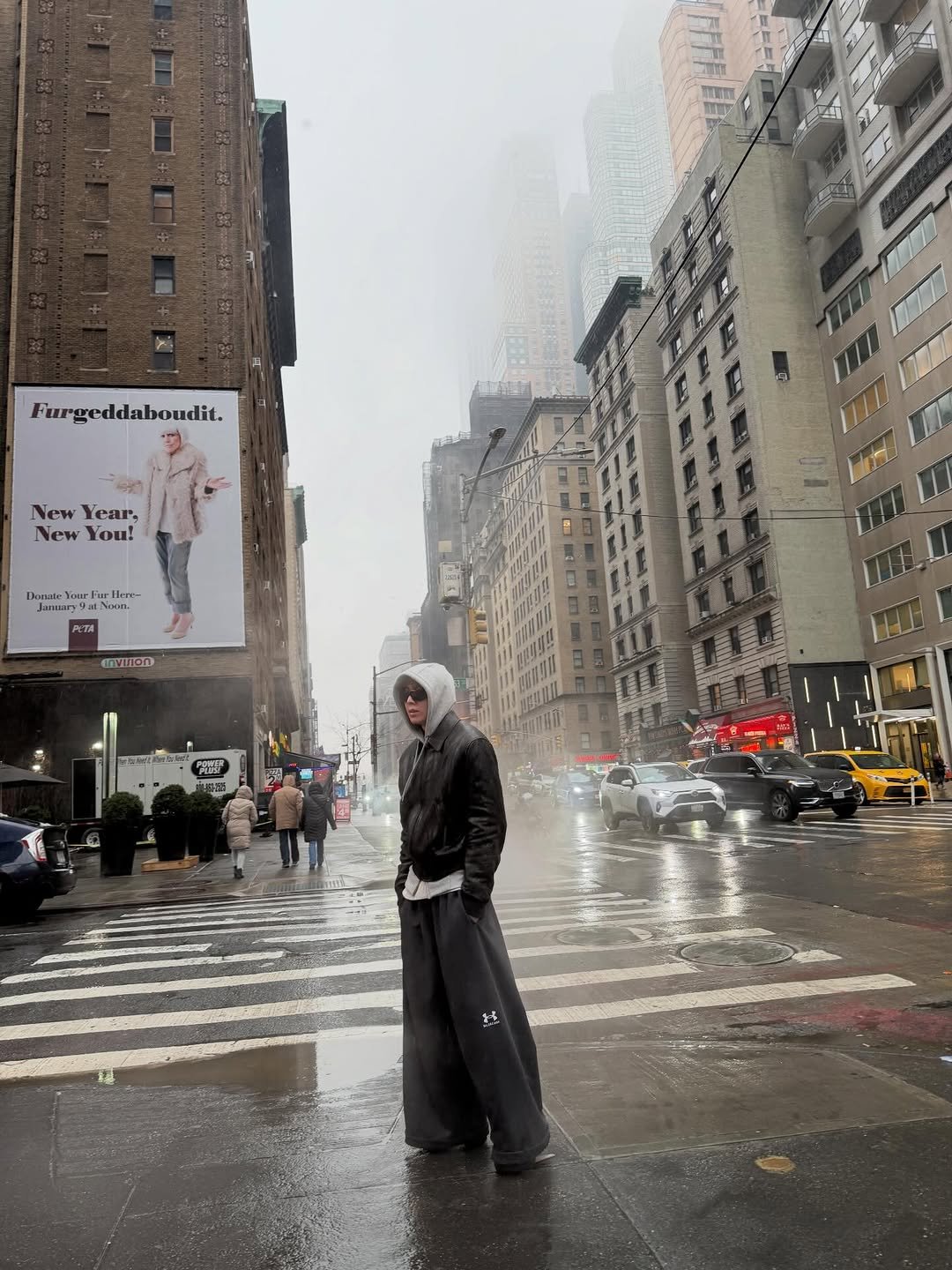 Photo by WOOCHAN • 우찬 on February 16, 2026. May be an image of standing, overcoat, raincoat, umbrella, Times Square, street and text.