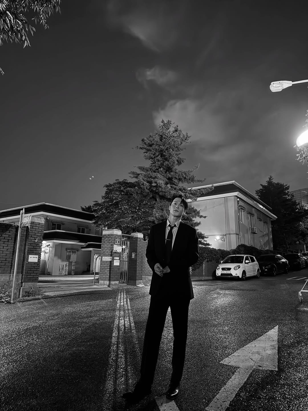 Photo by 장기용 on November 30, 2025. May be a black-and-white image of umbrella, street, curb and text.