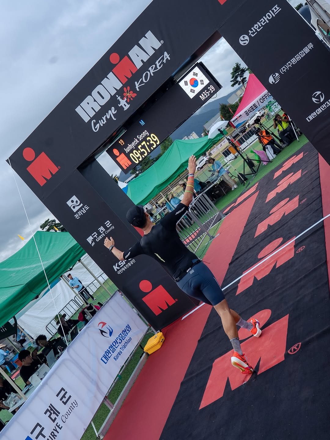 Photo shared by Junhyeok__s on September 28, 2025 tagging @web_monkey_. May be an image of ‎4 people, carpet, stadium and ‎text that says '‎신한라이프 (주)주평종합물류 學 OFFIO 중석포토 IRONMAN. 令 ពម 1 1 E 金 MB5 M35x39 M35-39 39 surye IRONK yeKOREA KOREA 19 19 JunBycuk 09:57:39 Seona JunhyeokSe m G 대한절인3 셀민3 13 N 전라남도 .. 난두 ព្មាជ 신 제럼 재간 데문 20 注.外製 VG Home 축현채육산 국연제차 KSI 유전충공연 رلع 대한 Korea 한절민3풍협회 KoreaTiinton Triathlon 구례군 군 례 County 구 RYE‎'‎‎.