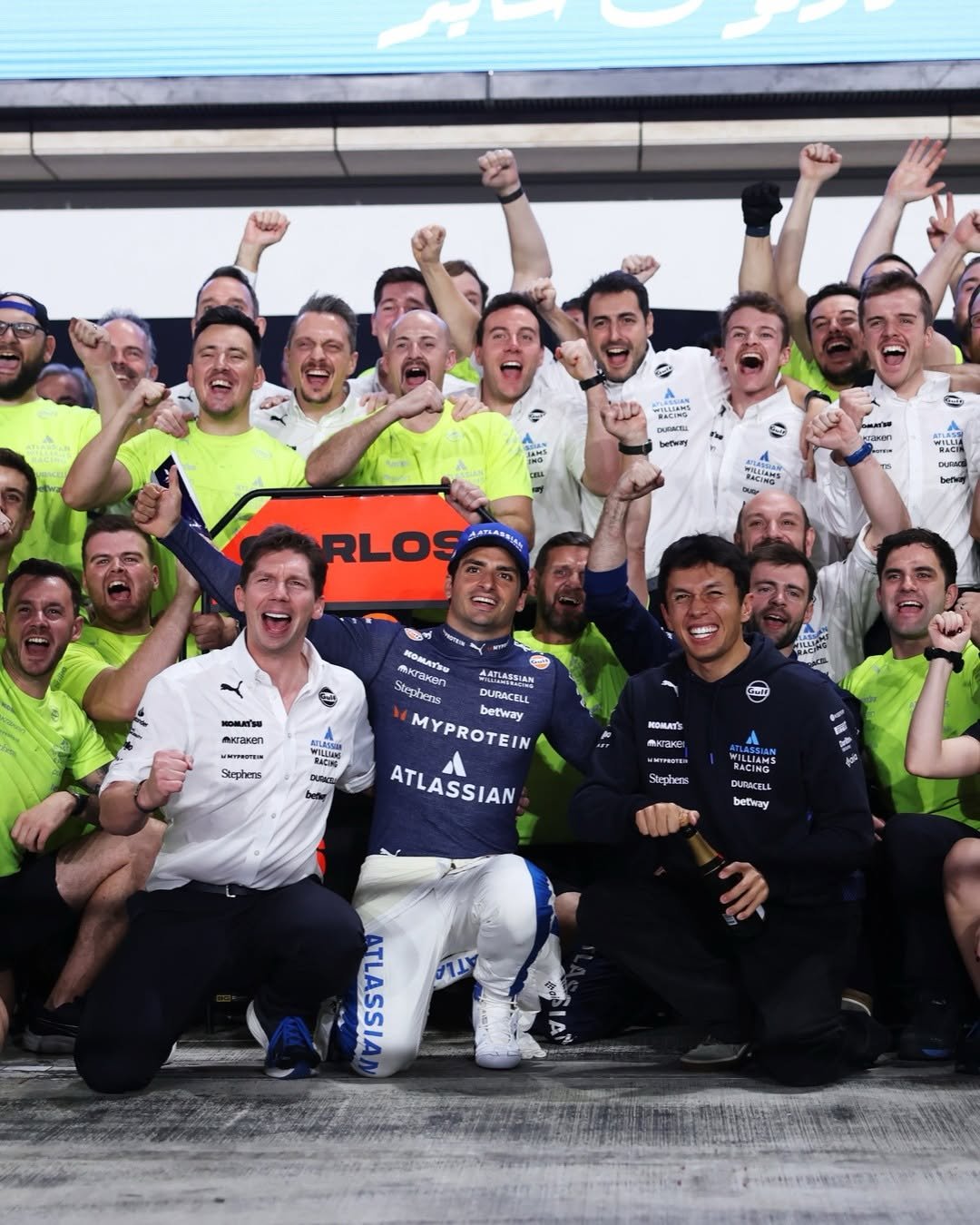 Photo shared by James Vowles on November 30, 2025 tagging @carlossainz55, and @alex_albon. May be an image of stadium and text.