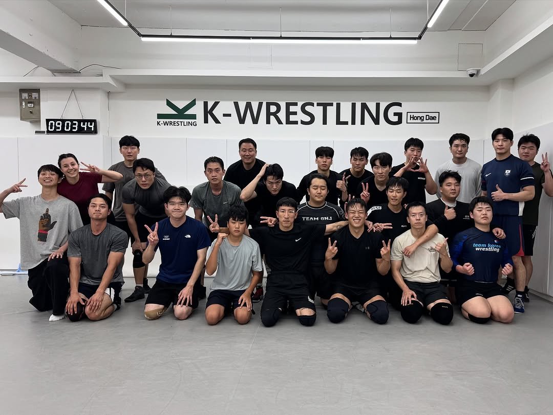 Photo by 케이 레슬링 홍대점 | 홍대•합정 레슬링 체육관 on October 06, 2025. May be an image of 14 people and text that says 'E 090344 44 09 K-WRESTLING K-WRESTLING Hang Dae TEAM SNJ wrestting'.