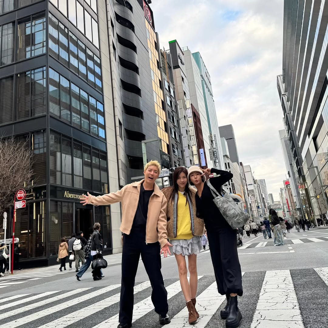 Photo shared by 강남 カンナム KANGNAM on March 26, 2026 tagging @hajiwon1023, and @sanghwazz. May be an image of one or more people, suit, Times Square, Tokyo Tower, street, skyscraper, buildings and text.