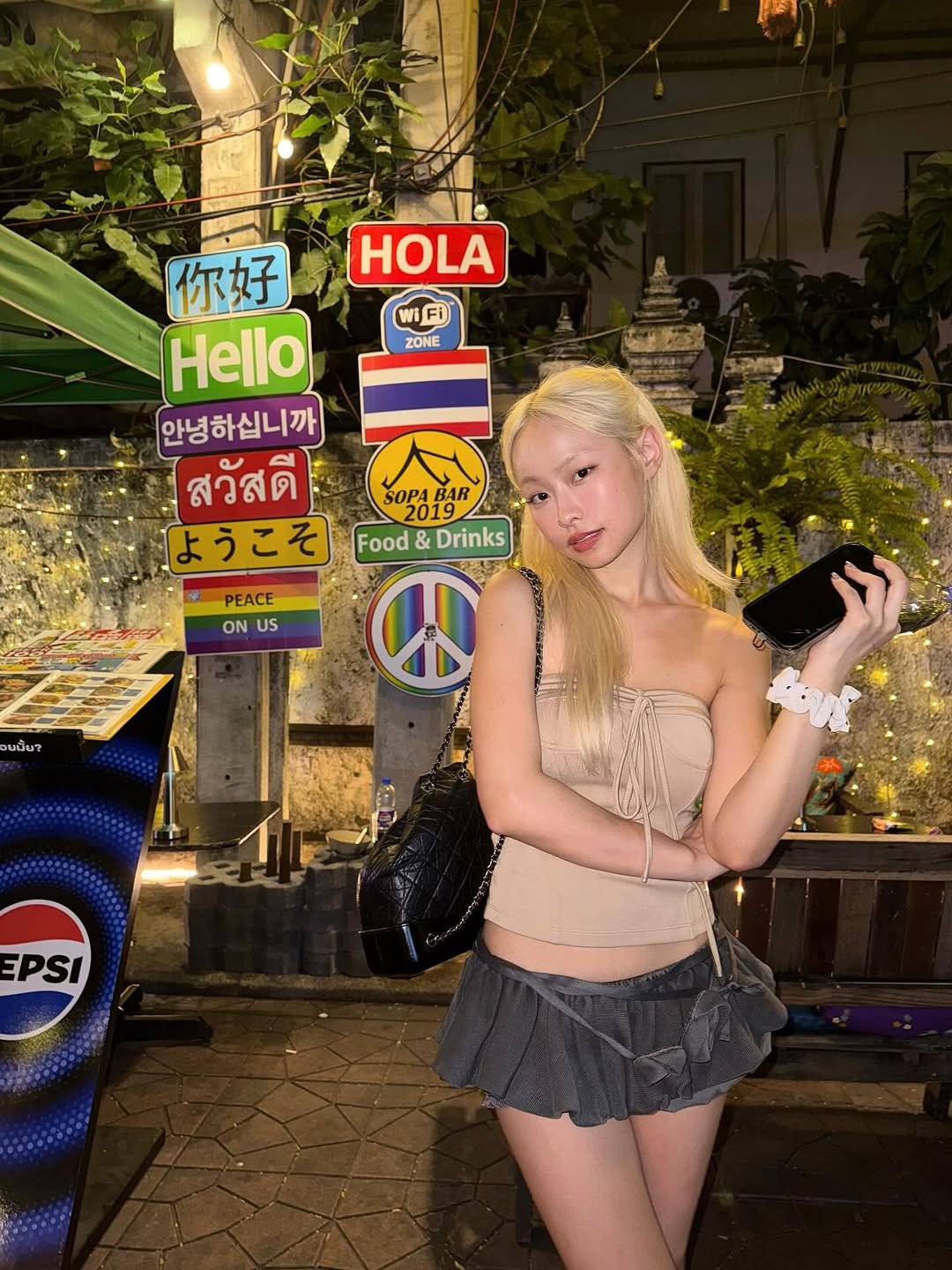Photo by Kanna︎︎ on July 26, 2025. May be an image of one or more people, blonde hair, miniskirt, dress, headdress, costume and text that says '၆်း၃ HOLA WiFi ZONE 你好 Hello 안녕하십니까 สวัสดี SOPABAR S0PA1R BAR SOPA 2019 ようこそ Food Food&Drinks & Drinks PEACE ON ONUS US บปิ๊น? EPSI'.