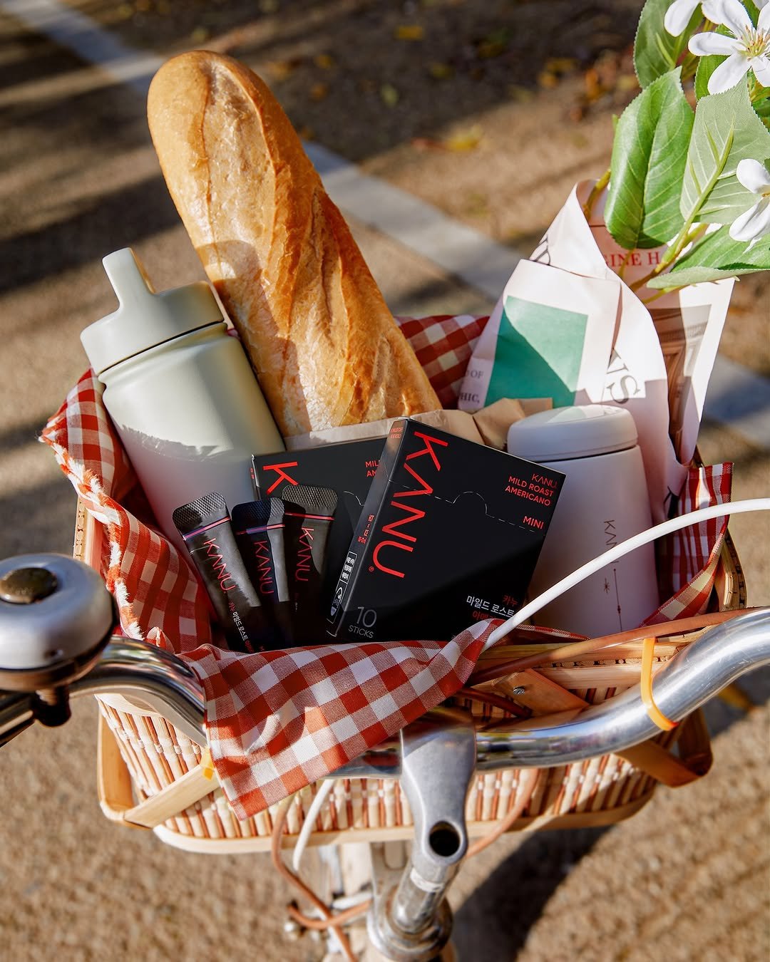 Photo by 카누 공식 인스타그램 on October 22, 2025. May be an image of bicycle, baguette, breadstick, basket, water bottle, hamper, picnic and text.