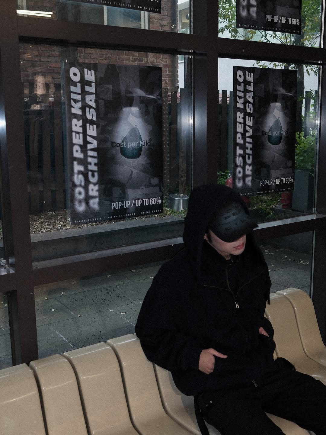Photo by Kasina_Hannam on October 17, 2025. May be an image of duffle coat, cigarette, parka, bench, face mask, window and text that says 'CIMY 3 KILO SALE AETR per COSTPER PER RCHIVE POP-UP/UPT060% 60% POP-UP/ ዑ/ሆ..601 T'.