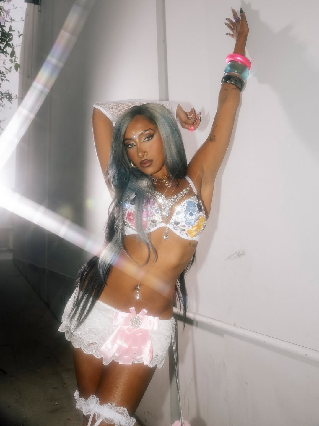 Photo shared by KATSEYE on April 27, 2026 tagging @lararajj. May be an image of one or more people, makeup, miniskirt, fishnet stockings, headdress and text.