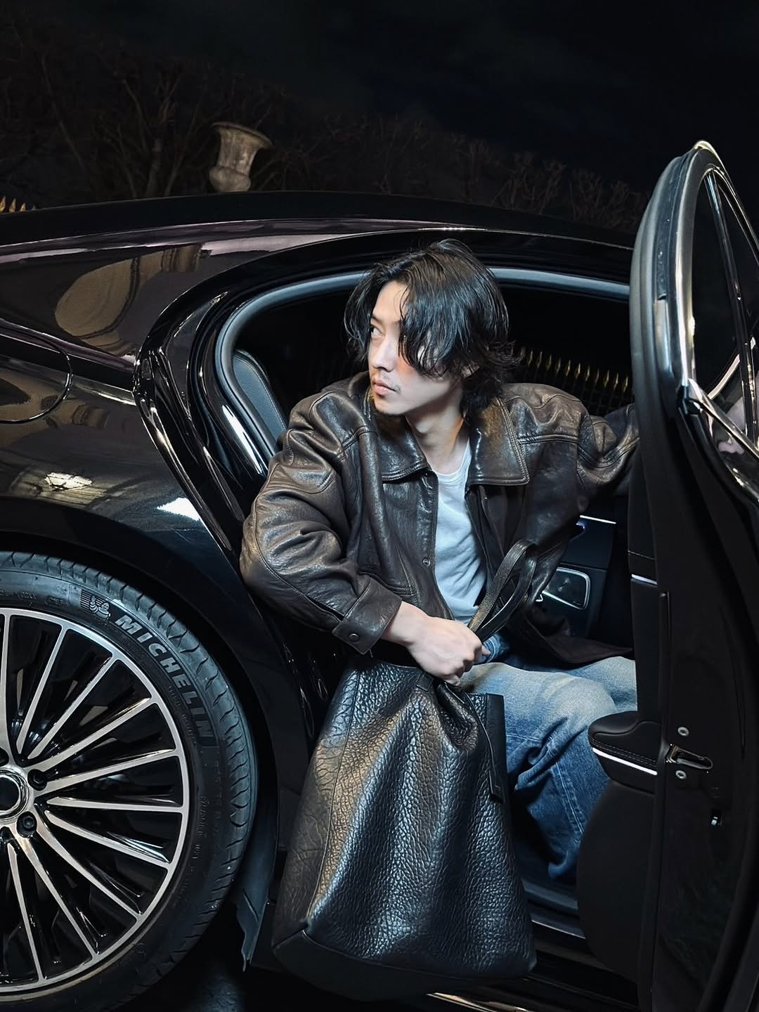 Photo shared by 山﨑賢人 on March 03, 2026 tagging @ysl, and @anthonyvaccarello. May be an image of leather, overcoat, car, limousine, jacket and text.